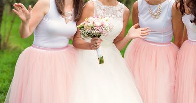 Beautiful young bride with her bridesmaids outside in nature