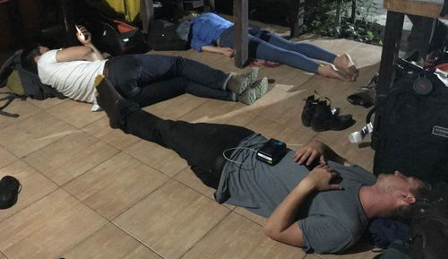 Covering a crisis: Reporter Sophie Walsh and her team attempt to grab an hour or two of sleep on the floor between television crosses. Lost bags and equipment have also contributed to difficulties sending satellite links back to Australia.