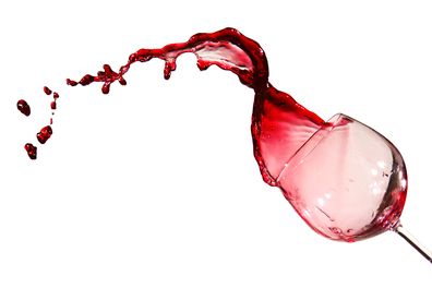 A glass of red wine tipping over