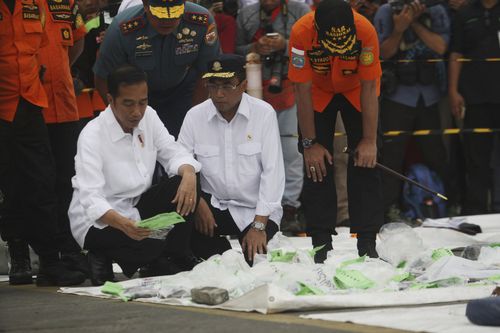 Indonesian President, Joko Widodo looks at some of the recovered items of victims.