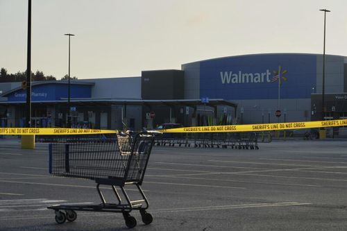 A shopping cart anchors police tape outside a Walmart where multiple people were stabbed in a violent attack Saturday