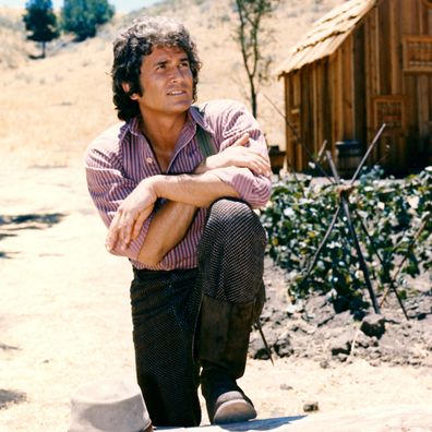 his knee with a log cabin the background in a portrait issued as publicity for the US television series, 'Little House on the Prairie', circa 1974. The drama, adapted from the novels by Laura Ingalls Wilder (1867-1957), starred Landon as 'Charles Ingalls'. (Photo by Silver Screen Collection/Getty Images)