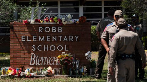 Flowers and candles are placed outside Robb Elementary School in Uvalde, Texas.