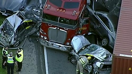 Crumpled and battered cars were crushed between two semi-trailers.
