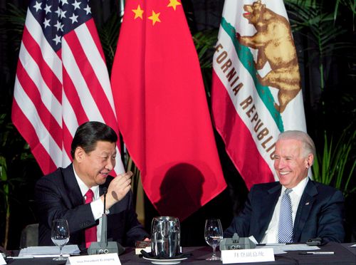 Xi Jinping, China's president and Communist Party chief, left, eats a Hawaiian macadamia chocolate with Joe Biden