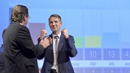  Leader of the Thuringia AfDy, Bjoern Hoecke, right, reacts after the first projections for the German general elections in Erfurt. (AAP)