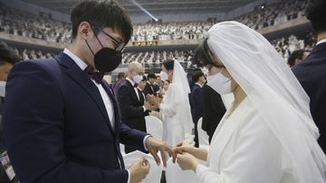 A couple wearing face masks exchanges their rings in a mass wedding ceremony at the Cheong Shim Peace World Center in Gapyeong, South Korea, Friday, Feb. 7, 2020. South Korean and foreign couples exchanged or reaffirmed marriage vows in the Unification Church&#x27;s mass wedding arranged by Hak Ja Han Moon, wife of the late Rev. Sun Myung Moon, the controversial founder of the church.