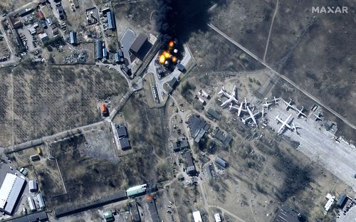 This multispectral satellite image provided by Maxar Technologies shows buildings and fuel storage tanks on fire at Antonov Airport, during the Russian invasion, in Hostomel, Ukraine, Friday, March 11, 2022. (Satellite image ©2022 Maxar Technologies via AP)