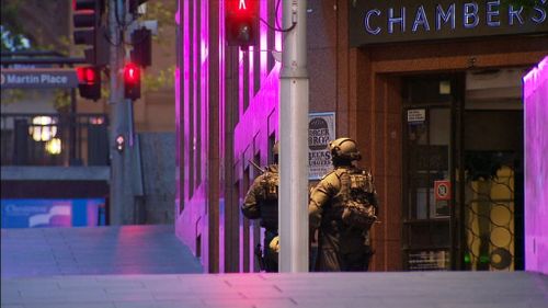 Night falls over Martin Place, as a captor holds hostages at gunpoint. (9NEWS)