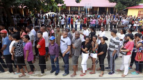 People queue up to give their vote during the presidential election at a polling station in Dili, East Timor.