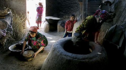 File image: A family bakes bread in the village of Dakhana Kiik, Tajikistan.