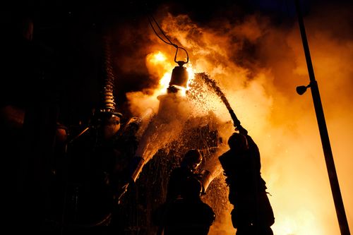 Ukrainian firefighters work to extinguish a fire in Kyiv