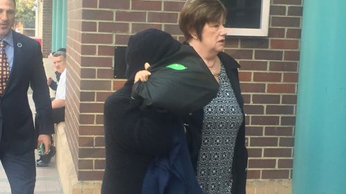 Jian Tang hid her face with a bag as she entered the court. (9NEWS)