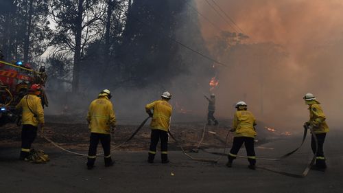 RFS protect a property impacted by bushfire on Hassall Road in Buxton due to the Green Wattle Creek Fire.