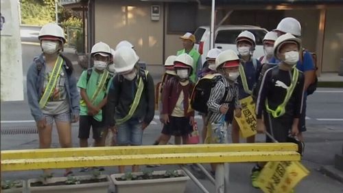 Japanese broadcasters showed students wearing helmets and masks on their way to school. 