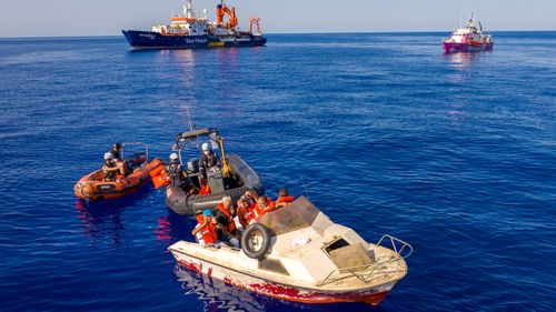 The pink rescue boat "Louise Michel" (back R) is pictured off the Libyan coast on August 22, 2020. The boat, helped to rescue 89 people on Thursday, according to a spokesperson for the vessel.