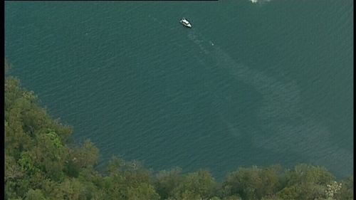 A long oil slick trail can be seen permeating from the shore.