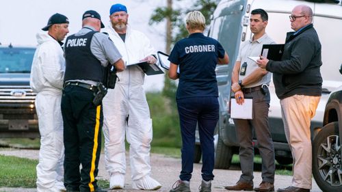 Investigators gather in front of one of the mass stabbing crime scenes in Weldon, Saskatchewan