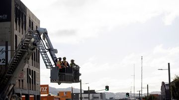 Investigators survey the scene of the Loafers Lodge hostel fire