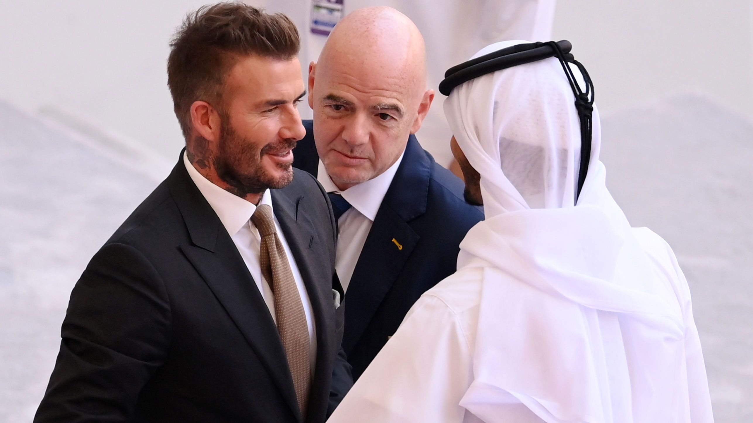 FIFA President Gianni Infantino (c) and former England player David Beckham (l) are seen in the stands prior to the Qatar FIFA World Cup Group B match between England and Iran.