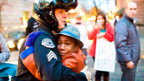 Portland police Sgt Bret Barnum and Devonte Hart, 12, hug at a rally in Portland, Oregon in 2014. (AP)