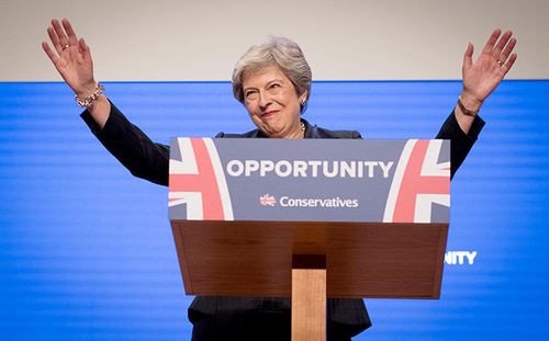 UK Prime Minister Theresa May waves to the audience at the Conservative Party conference in Birmingham.