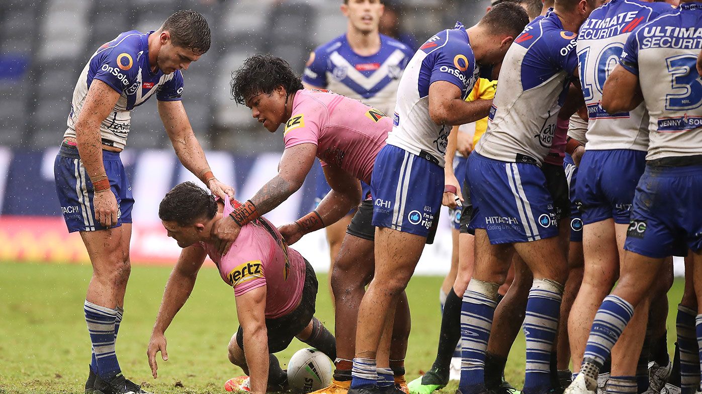 Nathan Cleary is helped up after a tackle by Dallin Watene-Zelezniak during the round two NRL match between the Canterbury Bulldogs and Penrith Panthers.
