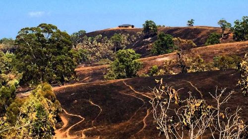 Flames spare a hill-top home by metres. (9NEWS)