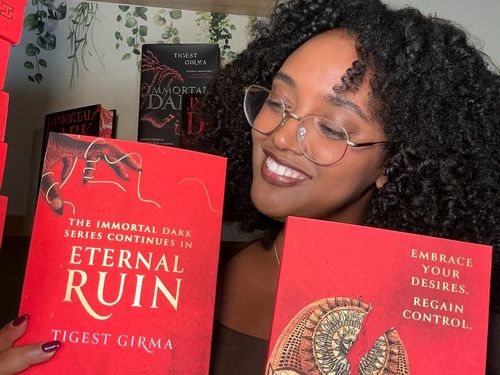Tigest Girma shows off copies of her second novel, Eternal Ruin.