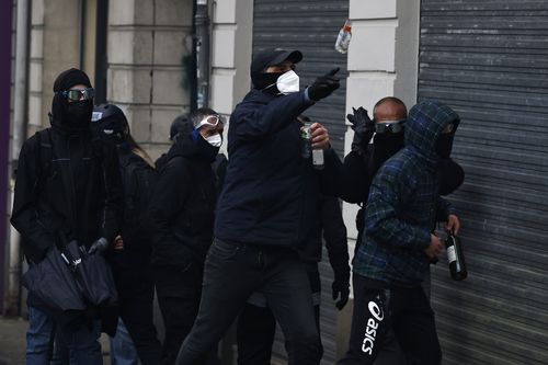Youths throw bottles during a protest Thursday, April 6, 2023 in Nantes, western France. 