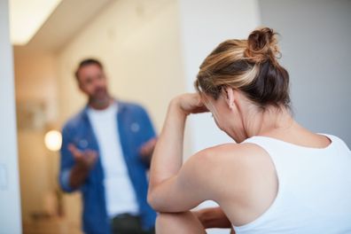 Rearview shot of an unrecognizable young woman looking distressed with her husband in the background