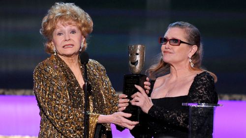 Carrie Fisher, right, presents her mother Debbie Reynolds with the Screen Actors Guild life achievement award in 2015. (AAP file image)