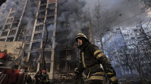 A firefighter walks outside a destroyed apartment building after a bombing in a residential area in Kyiv, Ukraine. 