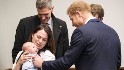 Prince Harry meets five-week-old James during a visit to Queen Elizabeth Hospital.