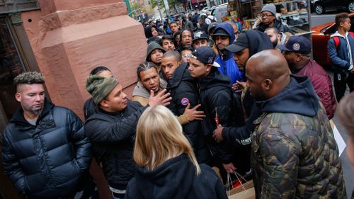 Costumers argue with a Nike Store Worker as they wait in line outside during the Black Friday sells on November 25, 2016, in New York. (AFP)