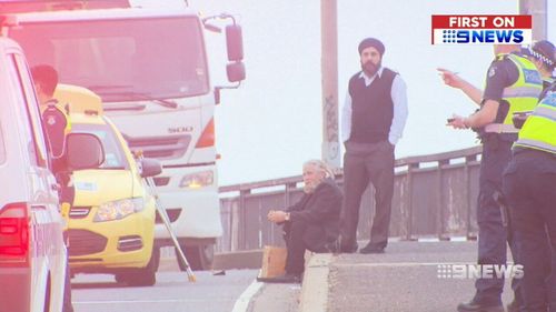 Rob, pictured seated, held the man's nearly severed arm in place while waiting for paramedics to arrive. (9NEWS)