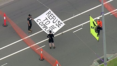 Three climbers have suspended themselves over the entries on Footscray Road and are refusing to come down. (9NEWS)